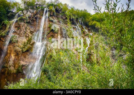 La grande cascade du parc national des lacs de Plitvice est une merveille naturelle, avec l'eau qui descend en cascade les falaises couvertes de mousse au milieu d'une végétation luxuriante. Banque D'Images