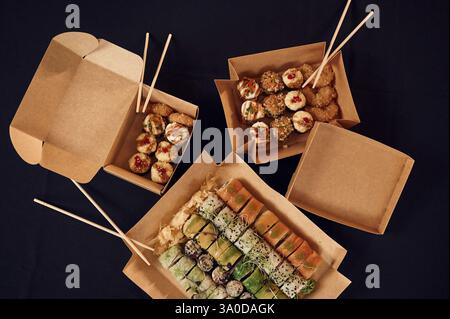 Vue de dessus des rouleaux de sushi qui est dans les boîtes ECO en papier sur la table. Banque D'Images