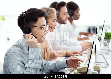 Concept de télécommunications. Des conseillers d'assistance téléphonique positifs vendant des biens ou des services au centre d'appels Banque D'Images