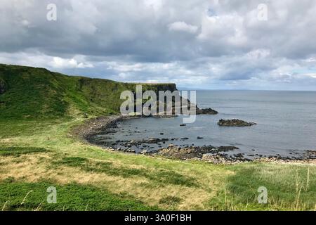 La spectaculaire partie côtière de la chaussée des géants d'Irlande du Nord avec sa verdure, ses falaises et ses formations rocheuses. Banque D'Images