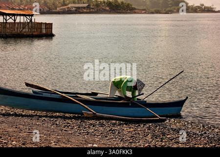 Pêcheur ponce sa barque et se prépare à vendre sa prise au marché humide local de Sogod, dans le sud de Leyte, aux Philippines. Banque D'Images