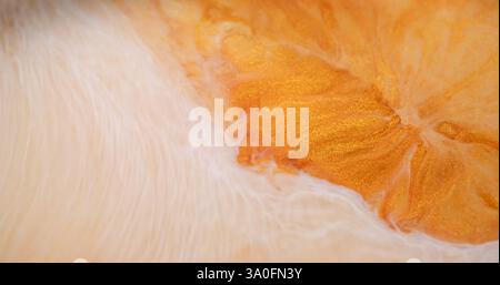 Taches d'encre. Flux de mélange. Texture de marbre d'eau chimique scintillante jaune doré blanc défocalisé se répandant sur fond abstrait. Banque D'Images