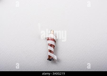 Figurine minuscule de l'homme modèle miniature enveloppés dans des bandages Banque D'Images