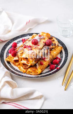 Crêpes roulées maison, flapjacks fourrés de fromage à la crème avec des baies fraîches Banque D'Images