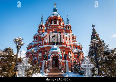 Une magnifique vue de face sur l'église de Kazan en hiver, mettant en valeur son architecture rouge éclatante, ses dômes d'oignon bleu et ses décorations festives, notamment Banque D'Images