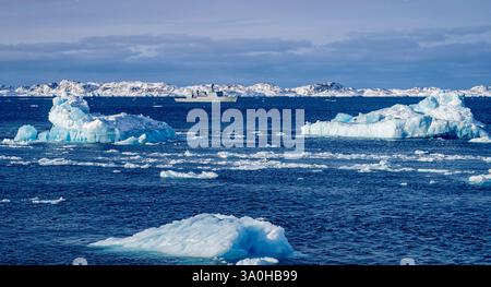 Une scène arctique sereine avec des icebergs flottants dans une mer calme, avec un bateau naviguant dans les eaux glacées. La toile de fond comprend lointain Snow-cov Banque D'Images