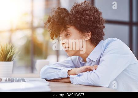 femme dans le bureau dormant sur le lieu de travail à l'ordinateur Banque D'Images