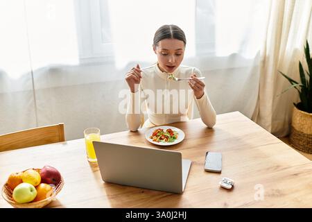 Jeune femme se livre à un repas nutritif, savourant chaque bouchée dans un cadre de cuisine confortable. Banque D'Images