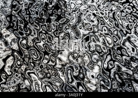 La lumière du soleil danse à la surface de l'eau, créant des motifs et des reflets abstraits. La scène capture la beauté de la lumière naturelle interagissant avec Mo Banque D'Images