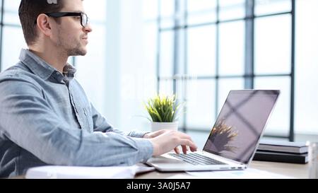 Un employé de bureau masculin utilise un ordinateur portable en gros plan Banque D'Images
