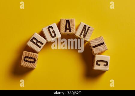 mot organique sur fond jaune écrit sur un bloc de bois. texte organique sur la table, concept. Banque D'Images