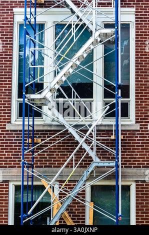 vue de face d'un échafaudage de jour en été sur la face d'un immeuble en briques à plusieurs étages Banque D'Images