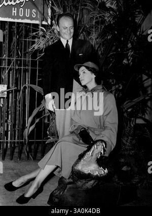 Paris Designer Pierre Balmain - défilé de mode au 96 Piccadilly. Les imperméables réversibles. Pierre Balmain avec mannequin dans Jockey Cap. 23 août 1950. (Photo par Daily mail Contract Picture) Banque D'Images