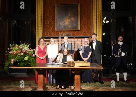04 mars 2025, Hambourg : Teresa Ribera, vice-présidente exécutive de la Commission européenne et commissaire européenne à la concurrence, signe le Livre d'or de la ville dans le Phönixsaal avant le traditionnel repas Matthiae du Sénat de Hambourg à l'hôtel de ville. Derrière elle se trouvent Carola Veit (à gauche, SPD), présidente du Parlement de Hambourg, Peter Tschentscher (3e à partir de la gauche, SPD), premier maire et président du Sénat de la ville libre et hanséatique de Hambourg, et son épouse Eva-Maria Tschentscher (2e à partir de la gauche), ainsi que Monika Schnitzer (3e à partir de la droite), économiste et présidente du Conseil allemand de l'Exp Banque D'Images