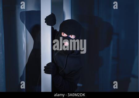 Cambriolage dans la maison par une porte en verre ouverte Banque D'Images