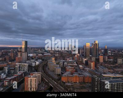 Une vue aérienne captivante mettant en valeur les gratte-ciel de Manchester au crépuscule, mettant en valeur l'architecture urbaine moderne, y compris la Deansga illuminée Banque D'Images