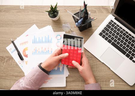 Mains masculines faisant des calculs au bureau. Gros plan Banque D'Images