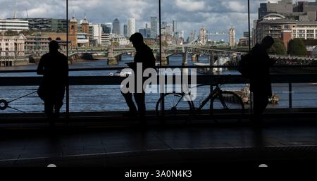 Les passagers du train attendent à la gare de Londres Blackfriers avec la ville de Londres, Royaume-Uni derrière Banque D'Images