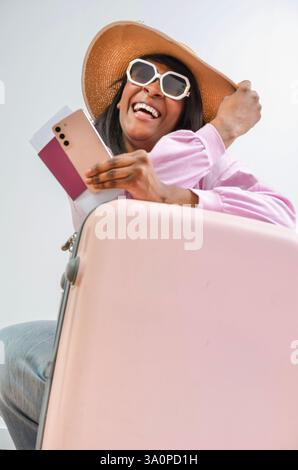 Heureux touriste détient passeport, smartphone et est prêt pour les vacances d'été Banque D'Images