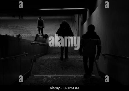 Monochrome des personnes descendant dans le sous-sol pendant l'hiver Banque D'Images