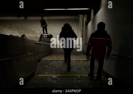 Un escalier faiblement éclairé place des figures de tête dans le métro de Montréal Banque D'Images