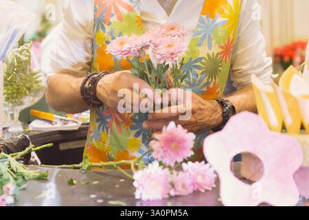 Homme fleuriste collectionnant le bouquet dans le magasin de fleurs Banque D'Images