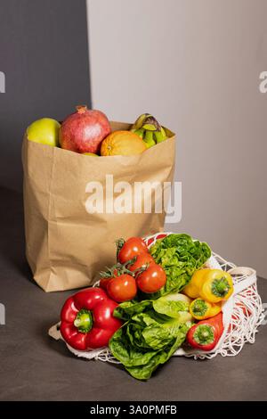 Un sac en papier rempli de fruits et de légumes frais de saison dans un sac shopper éco net sur la table de la cuisine Banque D'Images