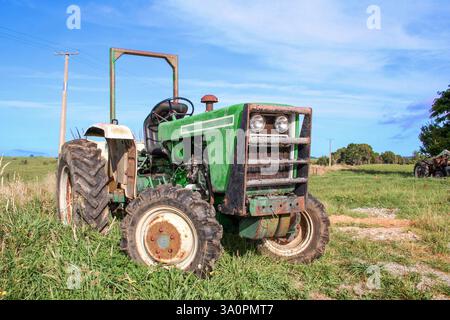 Tracteur agricole vert à l'extérieur sur la ferme dans une zone rurale. Banque D'Images