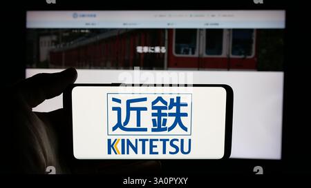 Allemagne. 4 décembre 2024. Dans cette illustration photo, une personne tient un téléphone portable avec le logo de la société japonaise Kintetsu Railway Co. Ltd sur l'écran devant la page Web de l'entreprise. (Crédit image : © timon Schneider/SOPA images via ZUMA Press Wire) USAGE ÉDITORIAL SEULEMENT ! Non destiné à UN USAGE commercial ! Banque D'Images