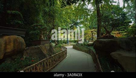 Chengdu, Sichuan, Chine. Marcher le long du sentier dans le parc à partir de la première personne. Arbres de bonsaï le long du sentier de randonnée dans le jardin. Jardin du temple mémorial de Wuhou Banque D'Images