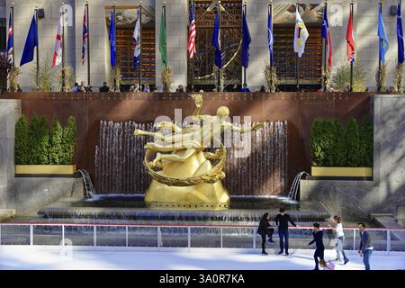 Sculpture de Prométhée au milieu d'une fontaine devant une patinoire, décorée de drapeaux internationaux, Manhattan, New York City, New York, U. Banque D'Images