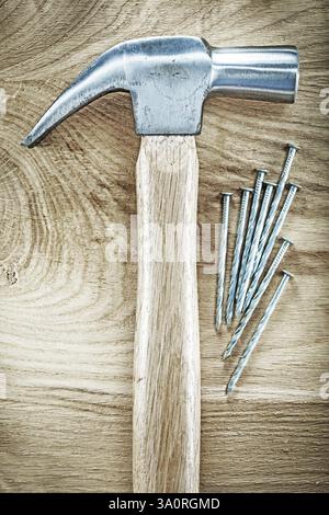 Clous métalliques de marteau de griffe sur le concept de construction de panneaux en bois Banque D'Images