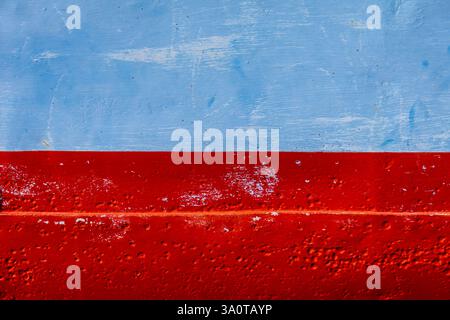 Gros plan de métal peint en rouge et bleu, présentant des surfaces lisses et texturées sous la peinture. Parfait pour le fond et la texture Banque D'Images
