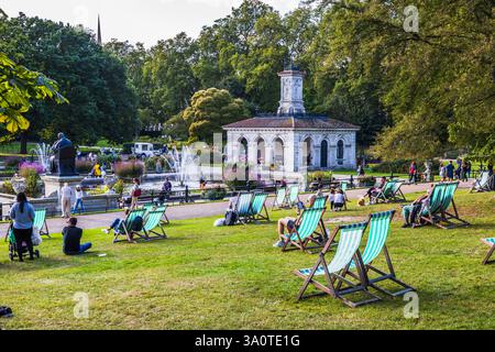Chaises Green Deck dans un parc urbain luxuriant avec des visiteurs détendus Banque D'Images