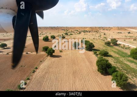 Vue du beau paysage du désert de Thar depuis un avion, Rajasthan, Inde. Les hélices et le thar désertent dans le cadre. Jeu de lumière du soleil. Banque D'Images