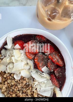 Bol Acai garni de fraises, de granola, de noix de coco et de graines de chia. Banque D'Images