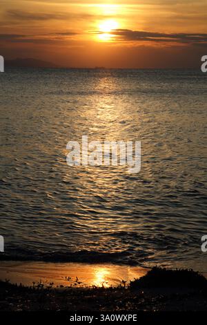 Coucher de soleil sur la mer Égée à Vouliagmeni Beach Attica Grèce Banque D'Images