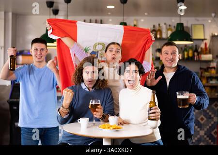 Les fans péruviens enthousiastes crient avec joie au bar à bière. Victoire péruvienne Banque D'Images