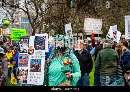 Sacramento, CA États-Unis - 4 mars 2025 : une femme déguisée en statue de la liberté bâillonnée avec des chaînes participe à l'événement démocratique du 50501 mars 4. Banque D'Images