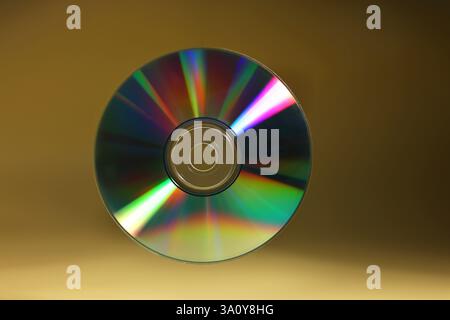 Un disque compact brillant sur fond jaune foncé Banque D'Images
