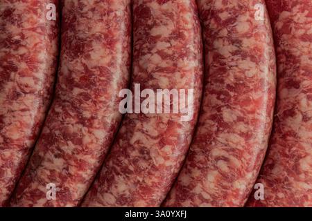 Gros plan de saucisses italiennes fraîches, mettant en valeur leur aspect marbré et leur enveloppe lisse. Banque D'Images