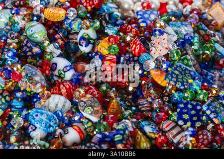 Fond multicolore lumineux de perles et bracelets en verre vénitien avec des motifs floraux complexes et des surfaces à facettes créant un éclat et des détails Banque D'Images