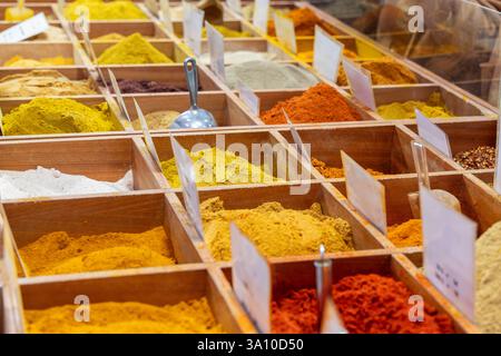 Une variété d'épices moulues colorées sont exposées dans des boîtes en bois sur un marché asiatique, y compris le curcuma paprika, le curry et le Chili utilisés pour la saison de cuisson Banque D'Images