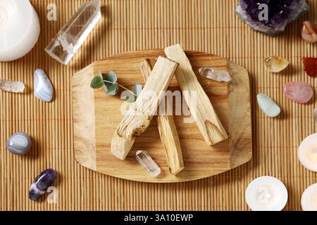 Palo santo bâtons et pierres précieuses sur la table en osier, pose à plat Banque D'Images