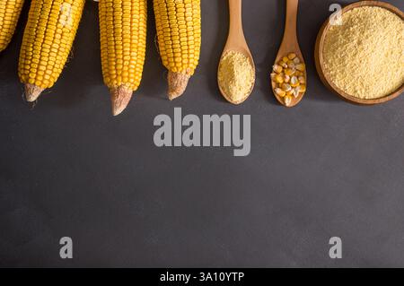 Farine de maïs dans un bol en bois et cuillère avec des gruaux de maïs séchés, des amandes sur une table rustique. Concept des ingrédients de maïs Banque D'Images