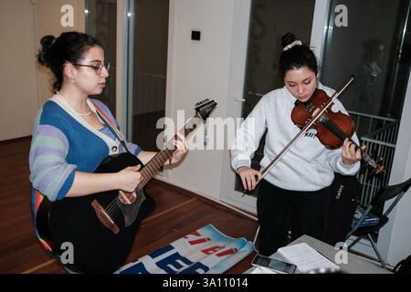 Izmir, Turquie. 05 mars 2025. Les femmes jouent de la guitare et du violon. Des femmes féministes ont organisé un atelier de bannières quelques jours avant le 8 mars, Journée internationale de la femme. Le 8 mars, ils préparent des banderoles pour la Marche nocturne féministe. Crédit : SOPA images Limited/Alamy Live News Banque D'Images