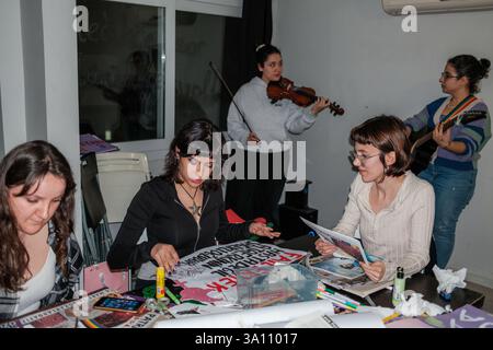 Izmir, Turquie. 05 mars 2025. Les femmes font de la musique tout en préparant des bannières. Des femmes féministes ont organisé un atelier de bannières quelques jours avant le 8 mars, Journée internationale de la femme. Le 8 mars, ils préparent des banderoles pour la Marche nocturne féministe. Crédit : SOPA images Limited/Alamy Live News Banque D'Images
