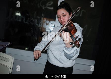Izmir, Turquie. 05 mars 2025. Une femme joue du violon. Des femmes féministes ont organisé un atelier de bannières quelques jours avant le 8 mars, Journée internationale de la femme. Le 8 mars, ils préparent des banderoles pour la Marche nocturne féministe. (Photo de Murat Kocabas/SOPA images/Sipa USA) crédit : Sipa USA/Alamy Live News Banque D'Images
