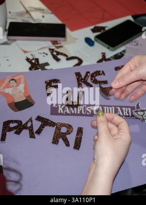 Izmir, Turquie. 05 mars 2025. (NOTE DE LA RÉDACTION : L'image contient du blasphème)femmes fabriquant des bannières à partir de symboles féministes découpés sur une table. Des femmes féministes ont organisé un atelier de bannières quelques jours avant le 8 mars, Journée internationale de la femme. Le 8 mars, ils préparent des banderoles pour la Marche nocturne féministe. (Photo de Murat Kocabas/SOPA images/Sipa USA) crédit : Sipa USA/Alamy Live News Banque D'Images