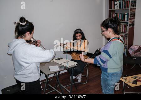 Izmir, Turquie. 05 mars 2025. On voit des femmes faire de la musique. Des femmes féministes ont organisé un atelier de bannières quelques jours avant le 8 mars, Journée internationale de la femme. Le 8 mars, ils préparent des banderoles pour la Marche nocturne féministe. (Photo de Murat Kocabas/SOPA images/Sipa USA) crédit : Sipa USA/Alamy Live News Banque D'Images